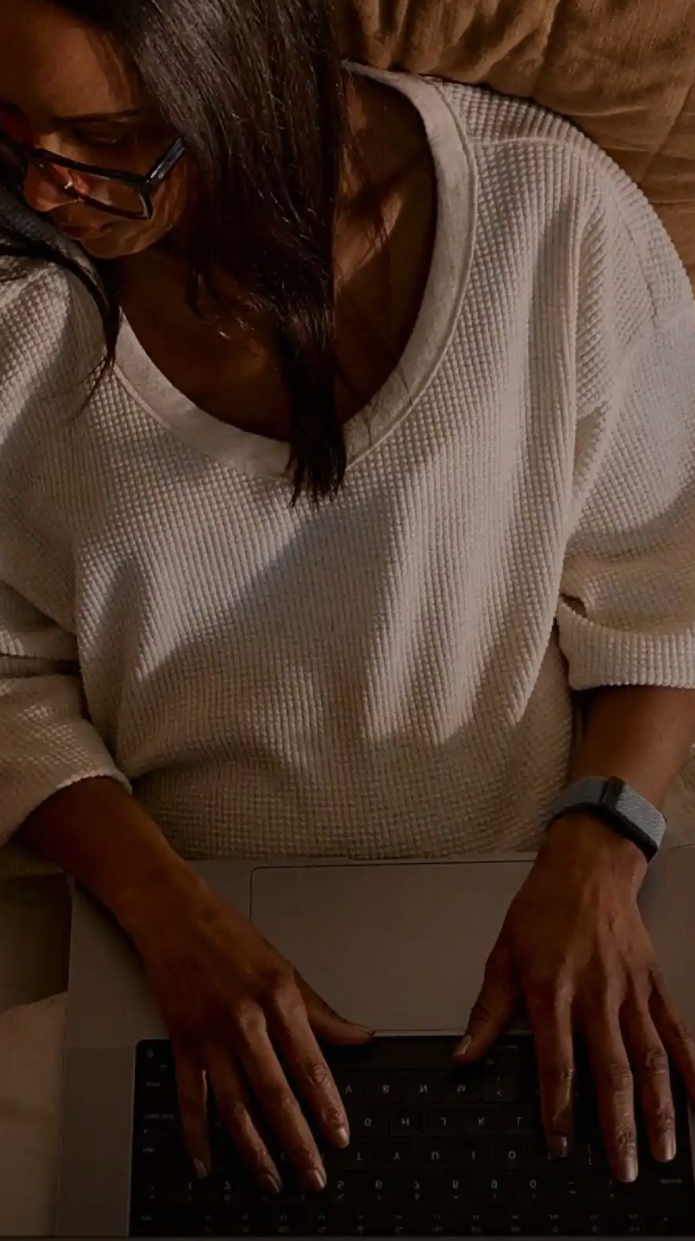 A woman and man in bed reviewing fitness data on a laptop, highlighting the integration of WHOOP insights with Stella’s skin metrics