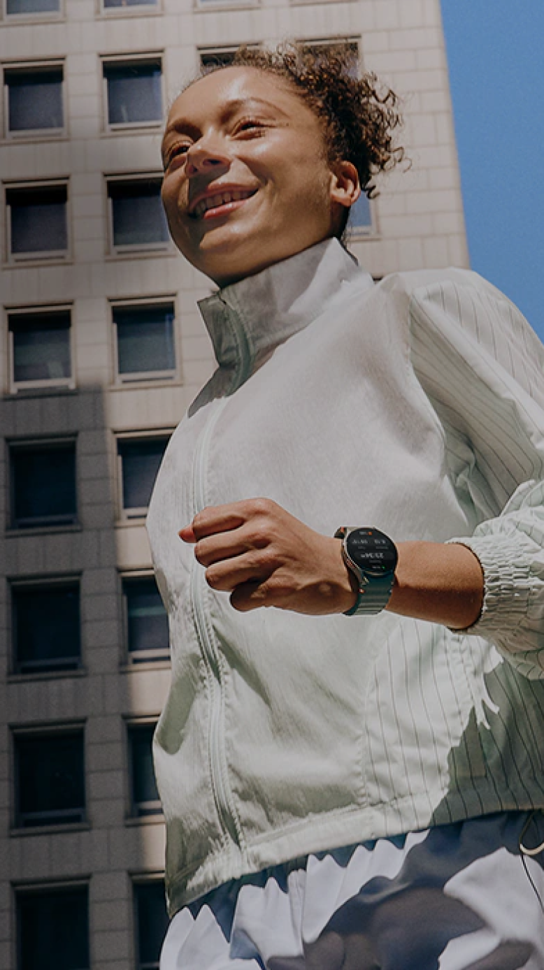 Woman wearing a Samsung Galaxy Watch smiling outdoors in a city