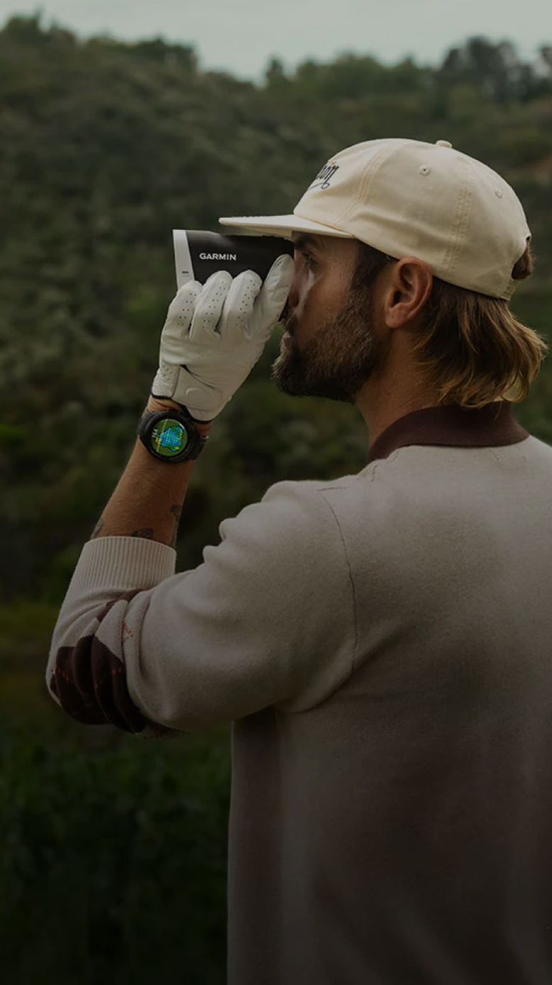 Man using a Garmin rangefinder, symbolising performance precision while playing golf.
